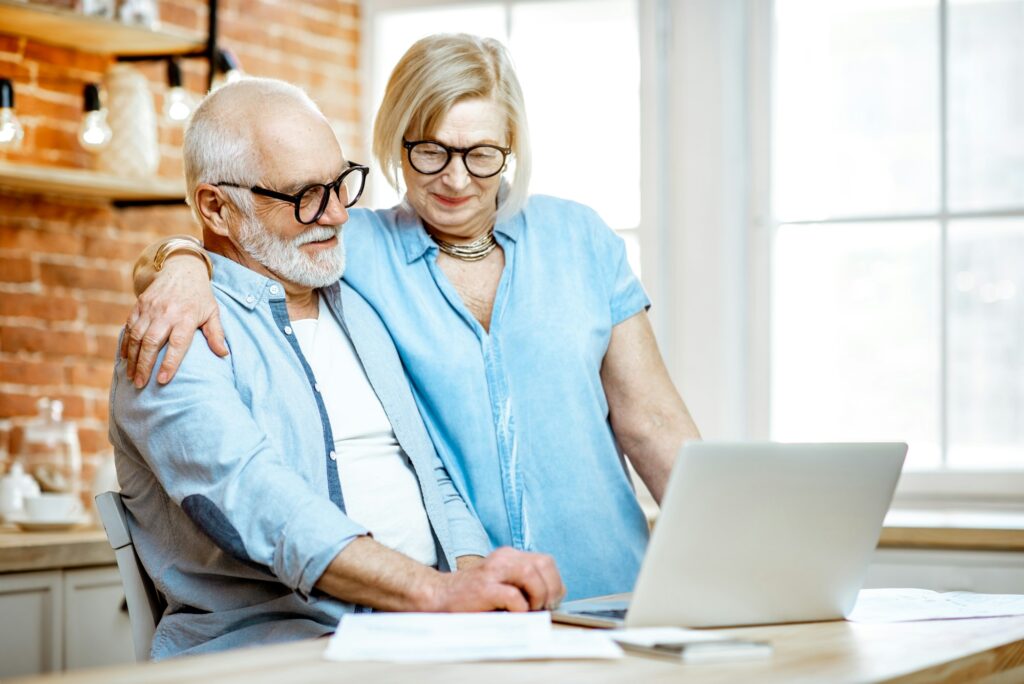 Senior couple with laptop at home